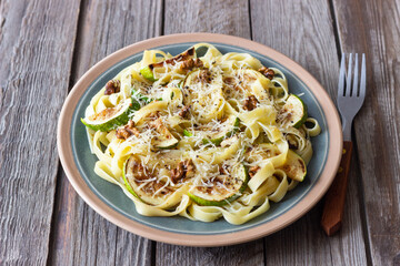 Fettuccine pasta with zucchini, nuts and parmesan cheese. Healthy eating. Vegetarian food. Italian cuisine.