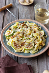 Fettuccine pasta with zucchini, nuts and parmesan cheese. Healthy eating. Vegetarian food. Italian cuisine.