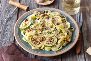 Fettuccine pasta with zucchini, nuts and parmesan cheese. Healthy eating. Vegetarian food. Italian cuisine.
