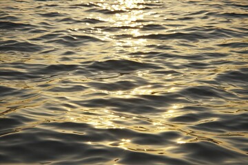 Golden sunlight reflecting on rippled water surface