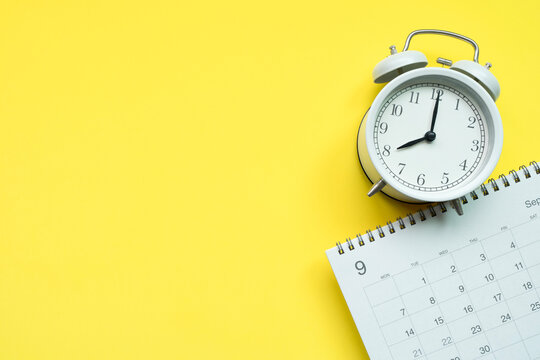 close up of calendar and clock on the yellow table background, planning for business meeting or travel planning concept