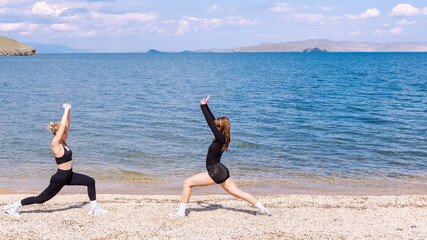 Women performing cardio training exercises on a sunny beach in the afternoon