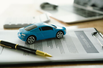 Car insurance contracts, agreements and policy details at a desk while reviewing documents and...
