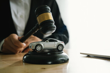 A gavel above a toy car represents legal authority in vehicle-related matters such as auctions, ownership, insurance, law enforcement, court rulings, and automotive business decisions.