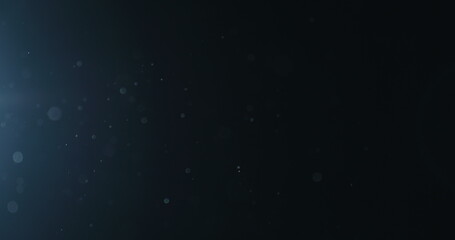 Slow motion natural dust particles float in air on black background