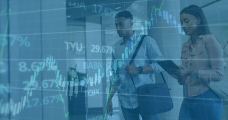 Two colleagues walking in lobby reviewing finance charts swiping tablet tapping panel for data - Powered by Adobe