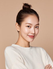 Commercial medium shot of attractive Korean woman in late thirties smiling in white sweatshirt with natural makeup on beige background
