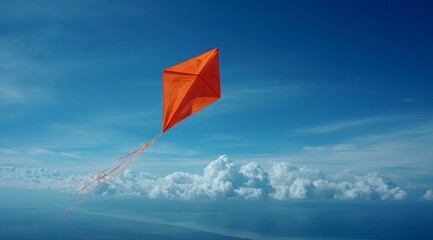 A kite is flying in the sky above a body of water. The kite is orange and is the only object in the image. The sky is clear and blue, with no clouds in sight