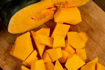 a piece of bright orange ripe pumpkin for cooking, cut into pieces sweet pumpkin in the kitchen