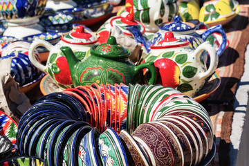 Colorful traditional Uzbek ceramic bowls and teapots at street souvenir shop in Bukhara, Uzbekistan