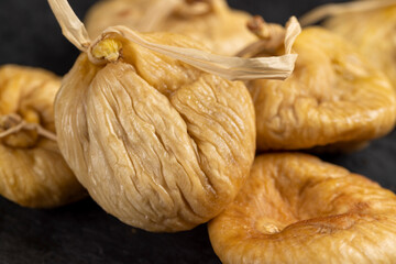 dried figs used in cooking close up, light figs naturally dehydrated in the sun on a black stone...