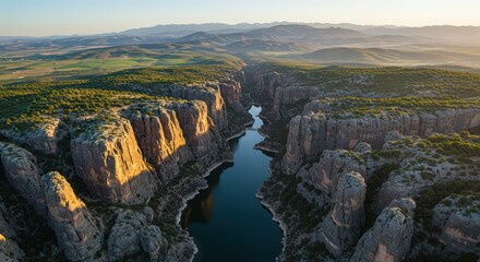Aerial view of a river flowing through a canyon with rock formations and distant mountain ranges