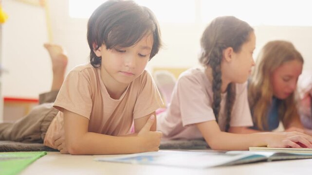  Group of Happy diverse boy and girl school student reading a book with friends in classroom. Children enjoy and fun learning, studying and playing for development knowledge education at primary schoo
