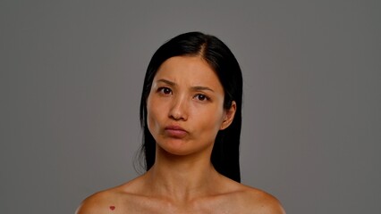 Obraz premium Woman Making a Puzzled Face Expression Against Neutral Background