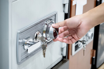 Turning wheel combination lock with analog number. Customer hand try to dial safe lock at home...