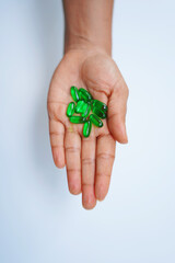 Vitamin E Softgel Capsules in Human Hand – Wellness Concept on White Background.