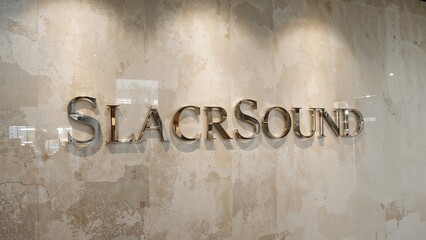 Transparent glass letters forming a logo on an old textured wall