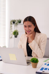 Asian Adult Businesswoman Engaged in Productive Work on Laptop in Modern Bright Office Environment