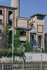 Abandoned Industrial Chimney Tower with Overgrown Vegetation