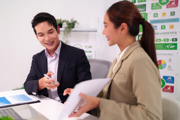 Asian Business Professionals Collaborating on Strategic Project in Modern Office Analyzing Data