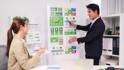 Adult Asian business professionals collaborate on ESG strategy green business meeting in modern...