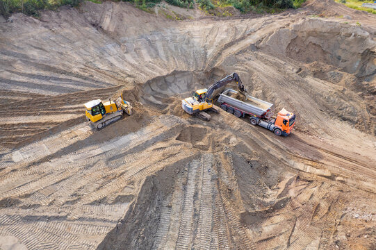 aerial view of quarry. excavator loading sand into dump truck