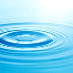 Close-up of concentric ripples expanding on a serene, light-blue water surface