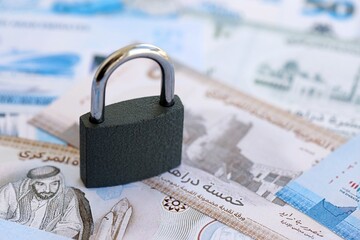 United Arab Emirates dirham currency money bills and padlock. The concept of sanctions and...