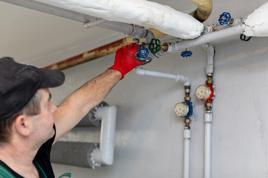 A Professional Plumber is Engaged in Working on an Industrial Piping System today