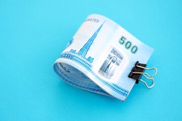 United Arab Emirates dirham money bills in big amount on blue. Finance and banking concept