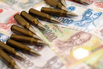Vietnamese dong currency money bills and rifle bullets. The concept of warfare and gun selling