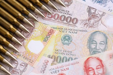 Vietnamese dong currency money bills and rifle bullets. The concept of warfare and gun selling