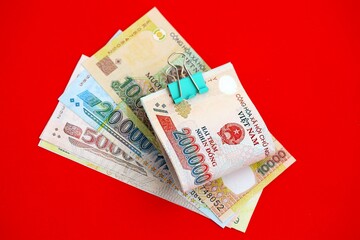 Vietnamese dong money bills in big amount on red. Finance and banking concept