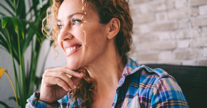 Middle-aged woman at home enjoying leisure time, using smartphone, dancing, surrounded by plants, smiling and relaxed, independent lifestyle, having fun, personal freedom, carefree and joyful moments - Powered by Adobe