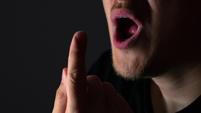 An adult man has a burn on his hand and blows on his finger to relieve the burning and pain.
A man on a black background blows on a burnt finger.
Burn injury due to fire safety violations