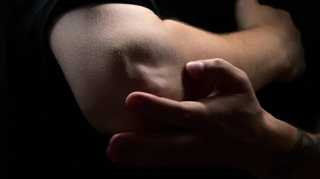 sprain or fracture of arm in adult muscular man in black t-shirt.
Male arm with arthritis or bruise symptoms.
Patient's arm pain due to muscle strain