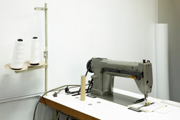 Fototapeta premium Designer work place sewing machine with with fabric and threads in office.