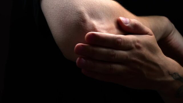 European man massaging injured elbow.
Elbow joint injury during sports.
Arthritis and joint problems.
Medicine and treatment concept