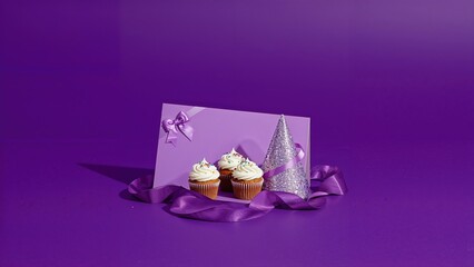 Party card showcasing cupcakes, a festive hat, and a wrapped gift against a violet background