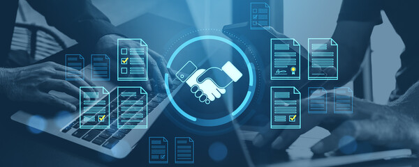 Digital contract agreement and document management concept with handshake icon and virtual files over people working on laptops in office workspace.
