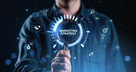 Businessman holding magnifying glass with marketing strategy hologram interface and digital...