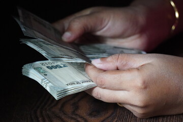 Female hands counting Indian 500 Rupee banknotes in closeup