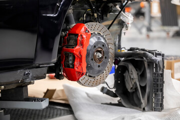 Front disc brake system on race car in process of damaged tyre replacement. The rim is removed...