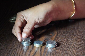 hand stacking Indian Rupee coins, which are the currency of India