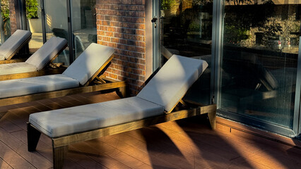 Sun-drenched loungers cast serene shadows, evoking lazy Sunday idylls and the meditative art of...