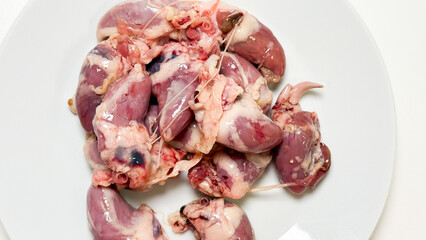 Raw chicken hearts glisten on a porcelain plate, evoking winter solstice feasts and carnivore cuisines secret heartwarming charms