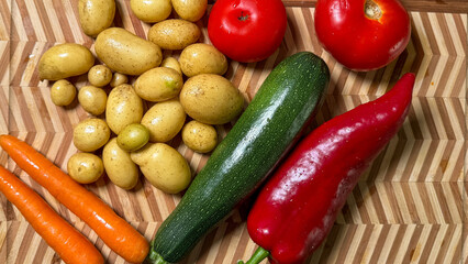 Rustic veggies ensemble on herringbone board, echoing abundance, harvest festivals, and quirky farmer's market textures