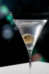 A shimmering olive-laden martini glass, capturing Twilight Cocktail Hour, under dappled starlight and dazzling mixology magic
