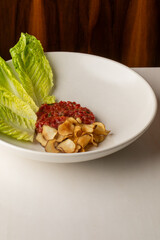 Chicory lettuce nests beside tangy beet tartare and crispy lotus chips; perfect for World Vegan Day celebration or Umami Fest