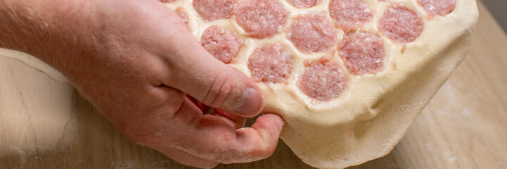 Sturdy hands craft homemade ravioli, dough embraces savory filling, evoking Cavatelli Day, culinary...